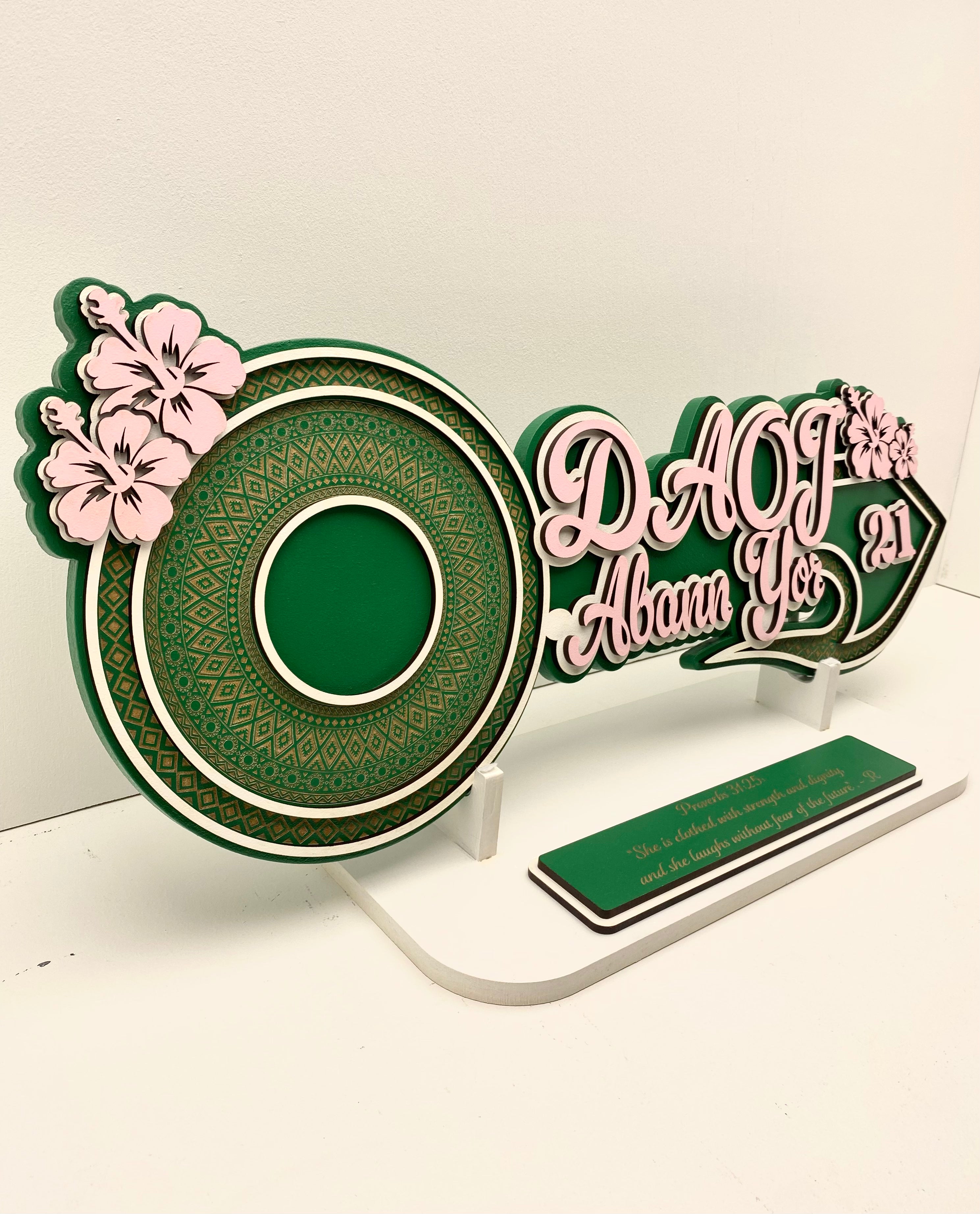 Decorative sign with floral designs and text on a white background